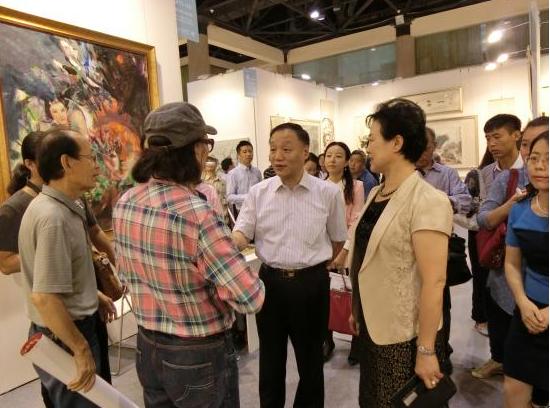 北京市文资办党委书记张慧光(右一)与艺术家石齐亲切交流